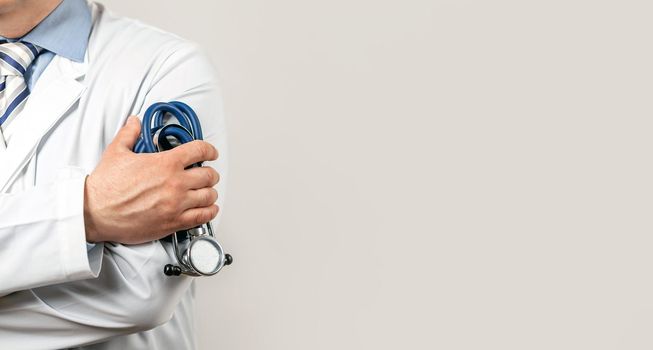Healthcare and medical concept. Medical doctor with a stethoscope in his hand. Male doctor pediatrician holding a rappaport stethoscope in his hand