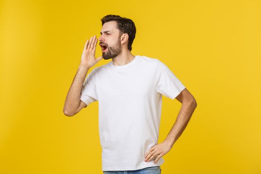 Portrait of a young man shouting loud with hands on the mouth