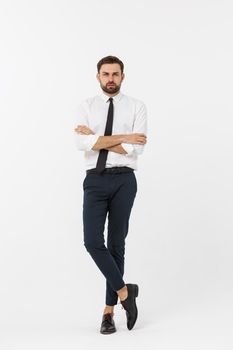 Portrait of a confident young businessman with hands in pockets on white background.