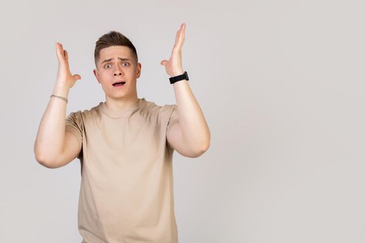 A handsome guy, a young man holding his head in his hands with happy excitement, cannot believe the good news