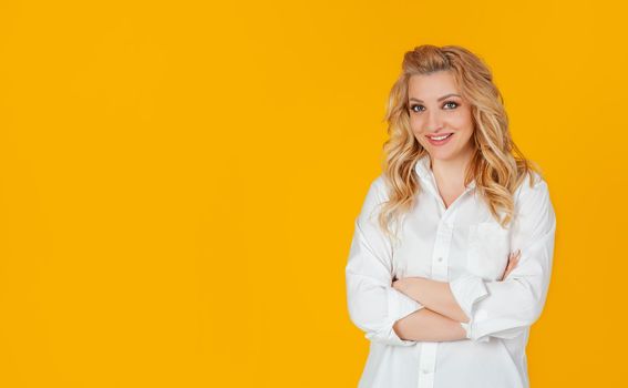 Attractive self-confident beautiful woman crossing her arms chest self-confident pose smiling energetic ready to achieve goals feeling lucky standing yellow background. Ready to start working today.