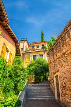 Staircase stairway of narrow street between stone walls. Scalinata Castel S. Pietro leading to Castel San Pietro in Verona city historical centre, blue sky background, Veneto Region, Northern Italy