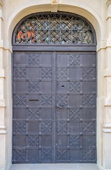 Old dark forged door with lock, wrought-iron metal