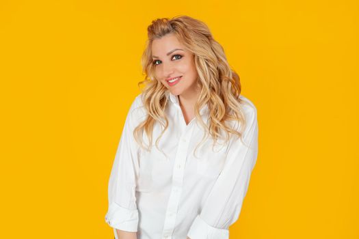 Blind woman in a white shirt, middle-aged European girl, laughs carefree cheerfully smiling, happily leaning forward cute silly, posing. Giggles, looks coquettishly, standing on a yellow background.
