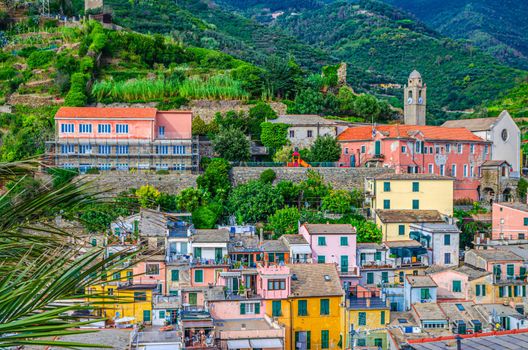 Top aerial view of green forest hills and typical colorful buildings houses in Vernazza village, National park Cinque Terre, La Spezia, Liguria, Italy