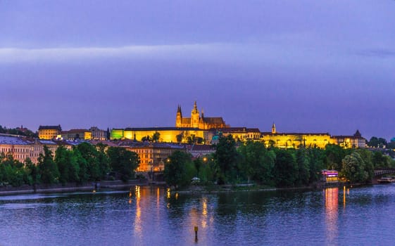 View of Prague old town, historical center with Prague Castle, St. Vitus Cathedral in Hradcany district, Vltava river, night evening twilight view, Bohemia, Czech Republic