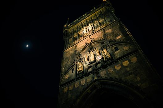 Crescent moon in evening sky over night Prague Old Town Bridge Tower on Charles Bridge Karluv Most, The beginning of the royal road to Prague Castle, view from below, Bohemia, Czech Republic