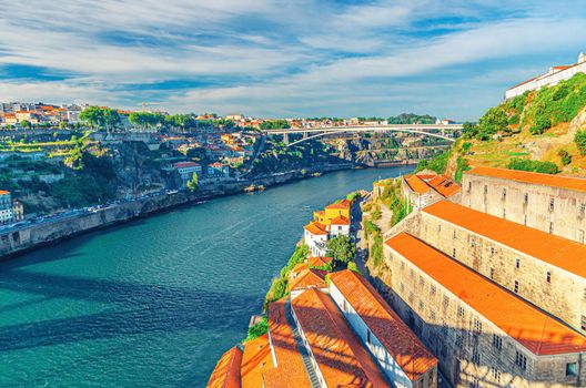 Aerial panoramic view of Porto Oporto city with Infante Dom Henrique Bridge ponte across Douro River and winery buildings on steep slope in Vila Nova de Gaia city, Norte or Northern Portugal