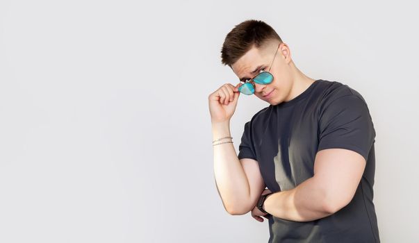 Handsome young man with sunglasses smiling with arms crossed. A positive person. Portrait of a positive cheerful guy crosses the arms of a real freelancer entrepreneur.