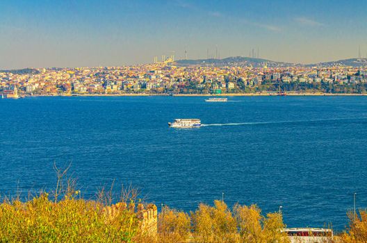 Cityscape of Istanbul city historical centre with ship boat sailing water of Bosporus Bosphorus Strait of Istanbul and Doganc lar district background, Turkey