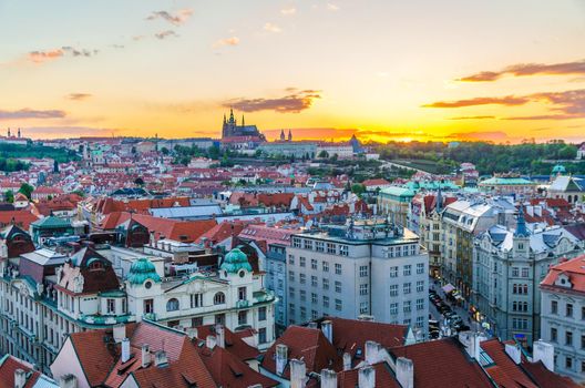 Top aerial panoramic view of Prague Old Town historical city centre with red tiled roof buildings and Prague Castle, St. Vitus Cathedral in Hradcany district in evening sunset, Bohemia, Czech Republic