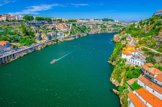 Aerial panoramic view of Porto Oporto city with Infante Dom Henrique Bridge ponte across Douro River with steep slopes between Ribeira district and Vila Nova de Gaia city, Norte or Northern Portugal