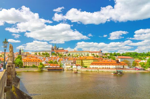 View of Prague old town, historical center with Prague Castle, St. Vitus Cathedral in Hradcany district, Charles Bridge Karluv Most over Vltava river, blue sky white clouds, Bohemia, Czech Republic