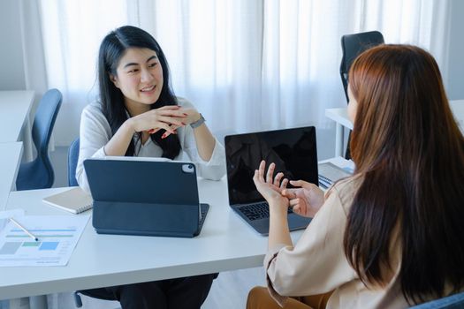 team work concept consultation An economic team analyst is using a tablet to discuss budgets and investments and financial planning with a female advisor in a conference room.