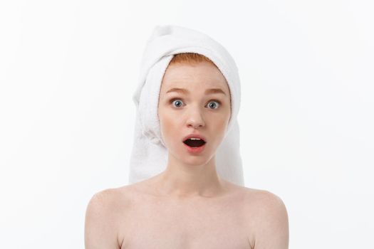 Surprised Beautiful Young Woman After Bath with A Towel On Her Head Isolated On white Background. Skin Care And Spa Theme