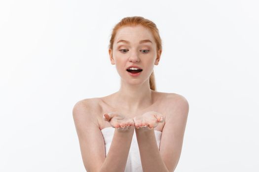 Skin care beauty woman showing empty palm with copy space for product. Excited smiling Caucasian female beauty model isolated on white background