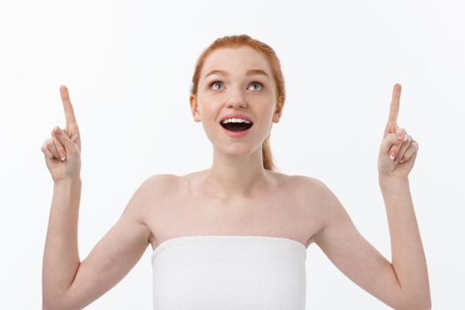 Portrait of young redhead female with perfect freckled skin showing something interesting at copy space wall for your advertising content