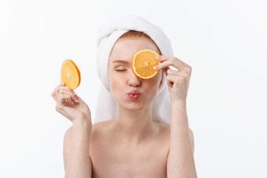 Great food for a healthy lifestyle. Beautiful young shirtless woman holding piece of orange standing against white background