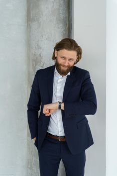 a handsome brutal bearded and long-haired man, a stylish businessman on a white background. High quality photo