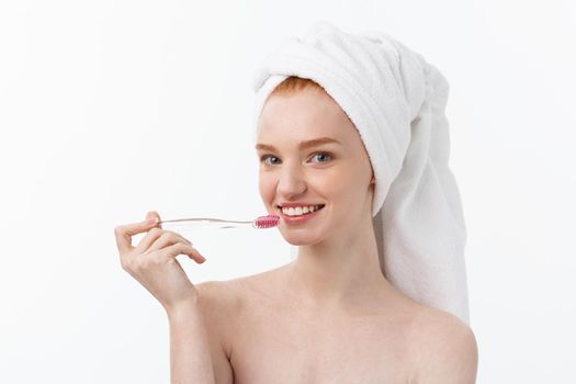 Portrait of young woman with toothbrush on grey background