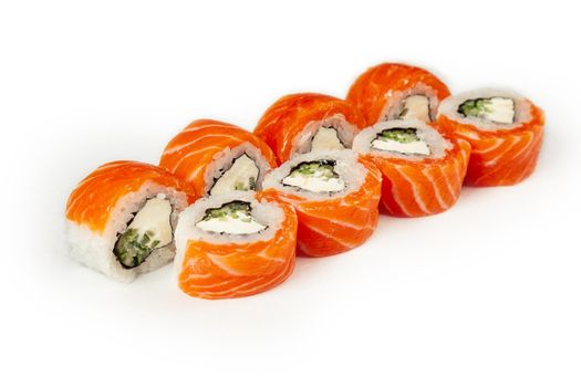 Sushi roll Philadelphia with cucumber on a white plate, classic Japanese sushi. Traditional Japanese food with maki. Delicious pieces of sushi. For the restaurant menu. copyspace.