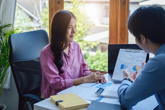 Teamwork concept, consultation, male economist pointing to budget, finance and investment documents, discussing and planning finances with female advisors in conference room.