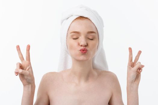 Beautiful caucasian woman applying mask on her face with two fingers sign white background