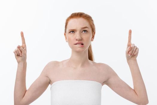 Portrait of young redhead female with perfect freckled skin showing something interesting at copy space wall for your advertising content