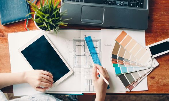 The desktop of the interior designer, the architectural plan of the house, the color palette. Drawings and plans for home decoration. top view color palette.