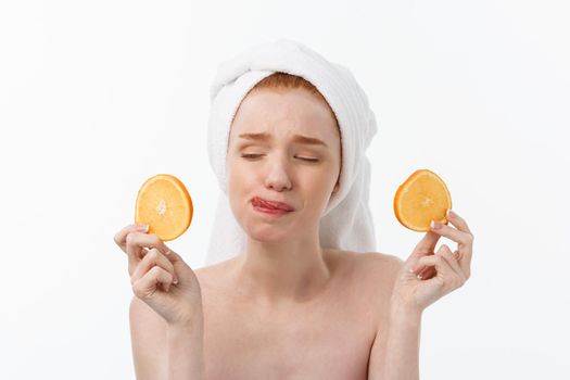 Great food for a healthy lifestyle. Beautiful young shirtless woman holding piece of orange standing against white background