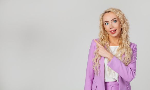 Intrigued, charmed, blond woman, surprised lady, surprised, open mouth, indicates the direction to the left, happy, raises her eyebrows. Wow, fantastic say more