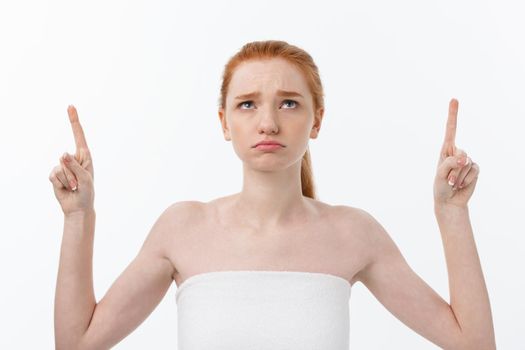 Portrait of caucasian cute in concern and shock, pointing index finger aside, over white background