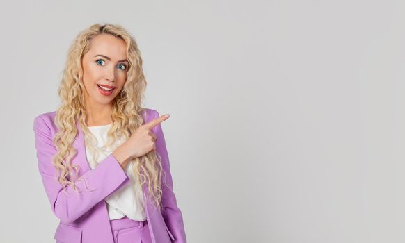 Intrigued, enchanted, blond woman, surprised lady, surprised, open mouth, indicates the direction to the right, happy, raises her eyebrows. Wow fiction say more