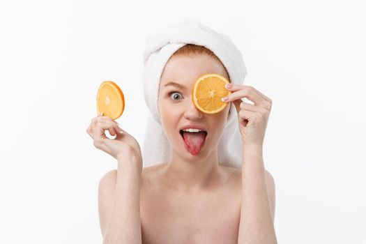 Great food for a healthy lifestyle. Beautiful young shirtless woman holding piece of orange standing against white background