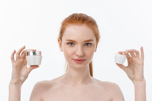 portrait of beautiful woman smiling while taking some facial cream isolated on white background with copy space