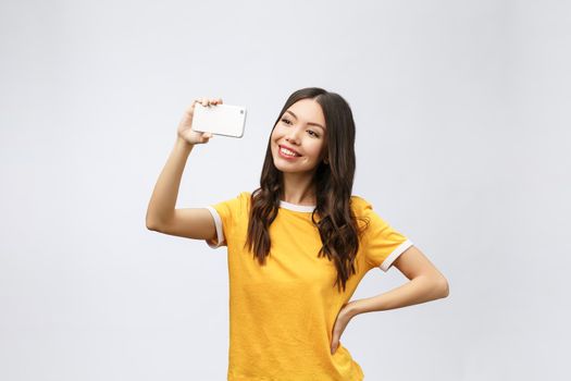 Image of excited happy young woman isolated over grey background make selfie by camera