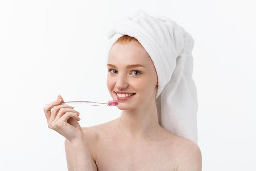 Portrait of young woman with toothbrush on grey background
