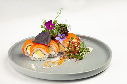 Sushi roll Philadelphia with avocado decorated with herbs on a plate, classic Japanese sushi. Traditional Japanese food with maki. Delicious pieces of sushi. For the restaurant menu. copyspace.