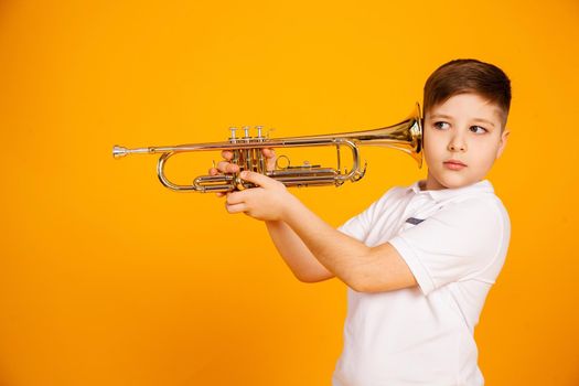 The boy overhears through the pipe. I want to hear everything. Handsome curious boy in a white shirt with a curious expression on his face while spying, eavesdropping, holding a pipe near his ear