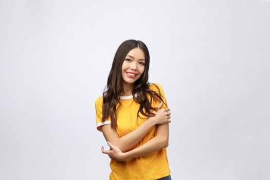 Beautiful young woman portrait. Smiling asian lifestyle concept with crossed arms. Isolated on grey background.