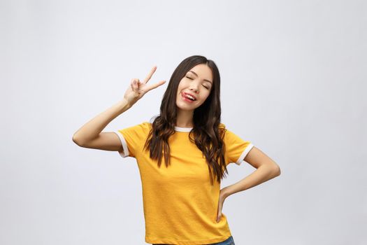 Happy young asian woman showing two fingers or victory gesture with blank copyspace area for text,Portrait of beautiful Asian woman isolated on white background.