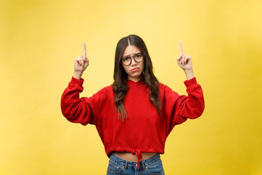 Young beautiful asian woman pointing to copyspace, isolated on yellow background.