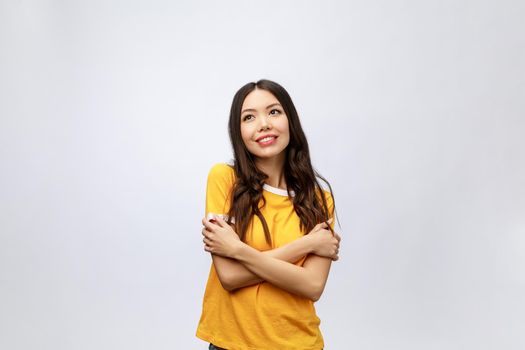 Beautiful young woman portrait. Smiling asian lifestyle concept with crossed arms. Isolated on grey background.