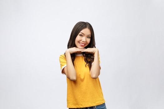 Portrait of good looking woman with long black hair against white background, smiling with hand on chin