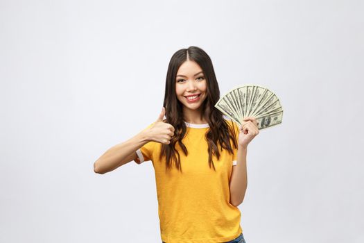 Closeup portrait of beautiful asian woman holding money isolated on white background. Asian girl counting her salary dollar note. Success wealth financial business cashflow currency payment concept.