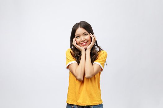 Portrait of good looking woman with long black hair against white background, smiling with hand on chin