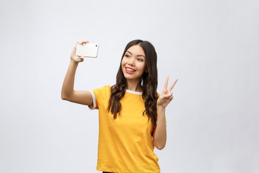 Image of excited happy young woman isolated over grey background make selfie by camera