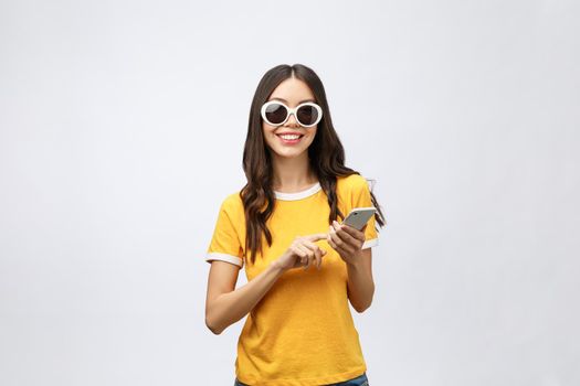 Content calm trendy nice cute adorable lovely attractive brunette caucasian girl with wavy hair in casual shirt, playing game in phone, isolated over grey background