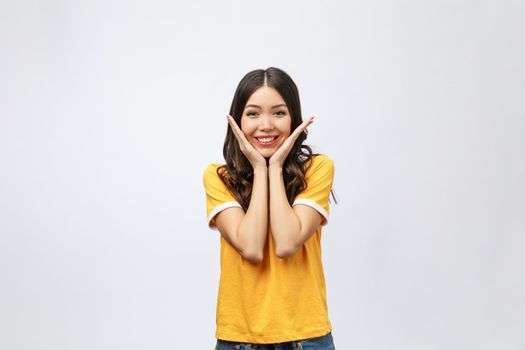 Portrait of good looking woman with long black hair against white background, smiling with hand on chin