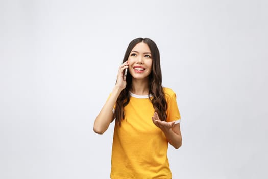 Beautiful young asian woman talking mobile phone and smile standing on grey background, freelancer female calling telephone, communication concept.